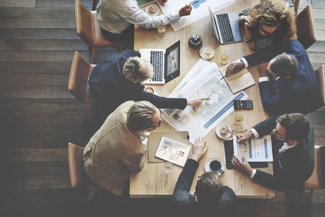 mesa com pessoas discutindo estratégias de negócios 