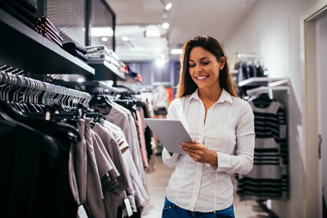 Vendedora de loja de roupa com um tablet na mão